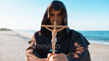 Jesus Crucifix In The Hands Of A Hooded Priest