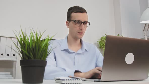 Man With Laptop In Her Office At The Desk Working