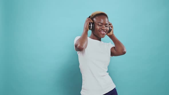 African Lady Dancing While Listening Music in Headphones