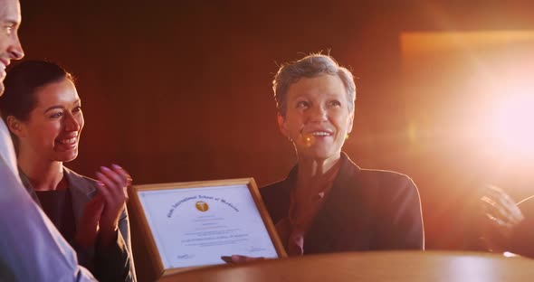 Female business executive receiving award