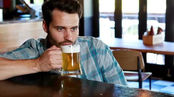 Sad man having beer at bar counter