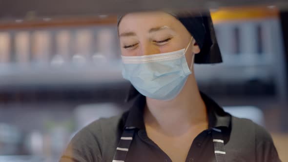 Closeup Portrait of Smiling Caucasian Chef in Covid19 Face Mask in Kitchen