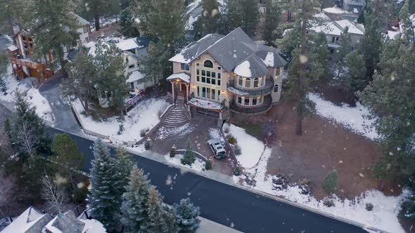 Luxurious large mansion with stunning exterior design and tall pines at snowfall
