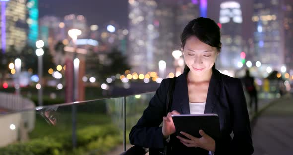 Businesswoman use of tablet computer at night