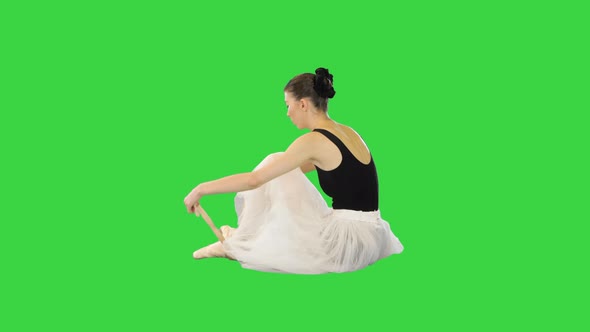 Young Ballerina Putting on Pointe Shoes on a Green Screen Chroma Key