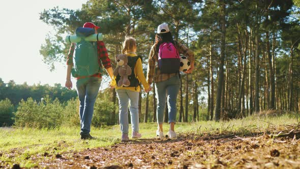 Happy Family Hiking Through a Forest