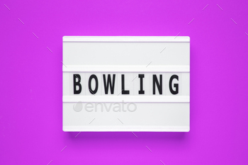 The word bowling on lightbox isolated purple background.