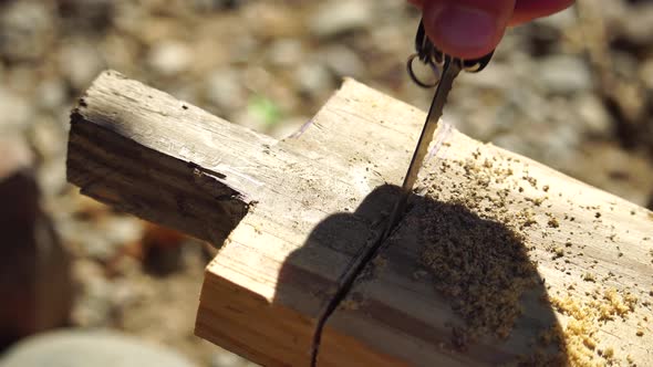 Using a Swiss Knife a Man Saws Wood Planks and Makes a Handle Outdoor Survival and Camping Fun in