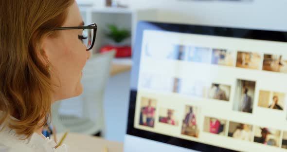 Side view of Caucasian female graphic designer sitting at desk in office 4k