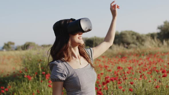 Young Girl Has Fun with Virtual Reality in a Field of Red Flowers