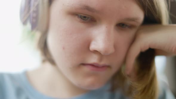 Teenage Girl Sits At Wooden Table In a Summer Cafe In Headphones With Phone