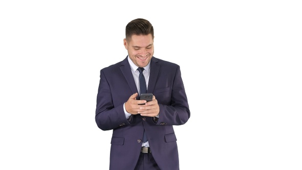 Businessman on the phone typing text message walking on