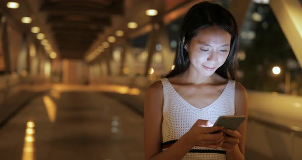 Woman working on cellphone at night 