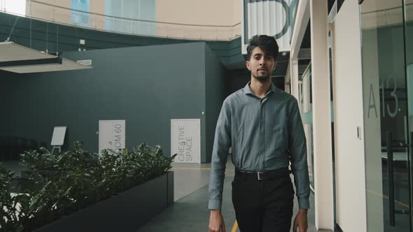 Portrait Young Serious Arab Man Entrepreneur Manager Boss Employee Walking in Trendy Modern Hall