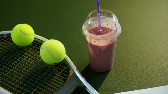 Milkshake and sports equipment in tennis court 4k