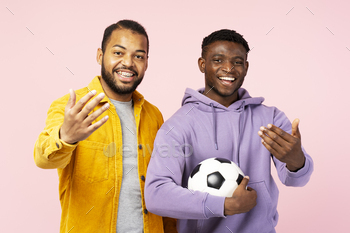 Happy smiling African American friends, soccer players holding soccer ball