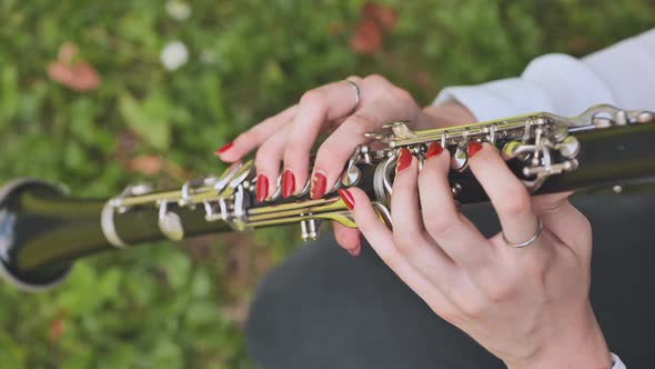 A Girl Plays the Clarinet in the Summer in the Park