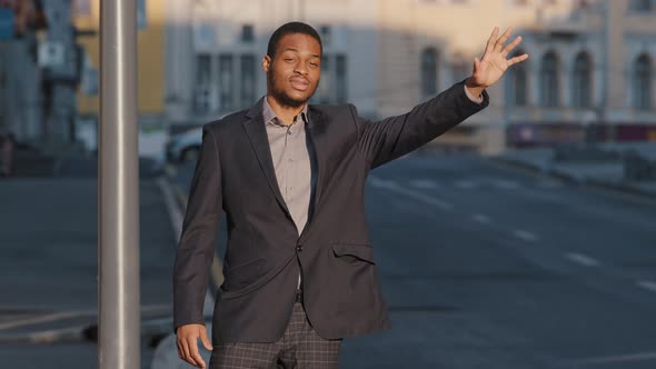 Attractive African American Student Young Guy in Suit Waiting for Cab Outdoors