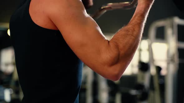 Close-up of Unrecognizable Young Man with Muscular Wiry Body Lifting Barbell.