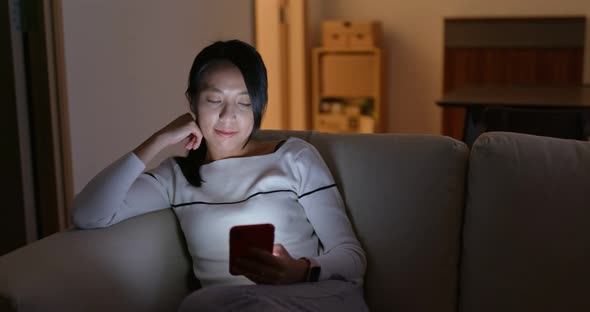 Woman Look at Mobile Phone and Sit on Sofa