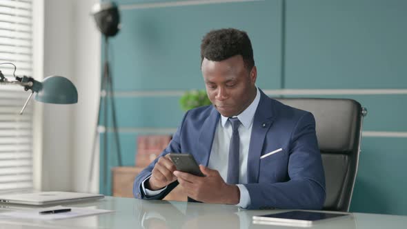 Successful African Man Celebrating on Smartphone