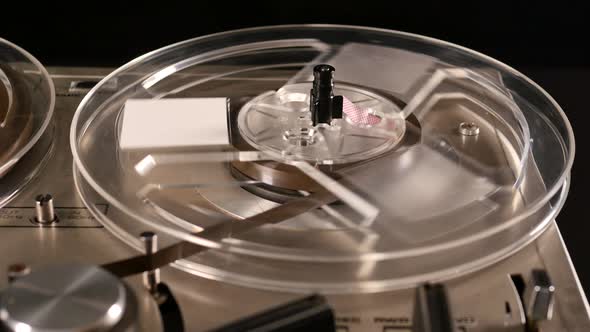 Vintage Reel to Reel tape recorder playing music close up of reel