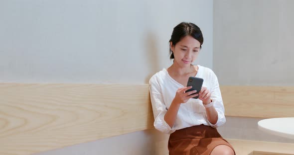 Woman use of smart phone inside coffee shop