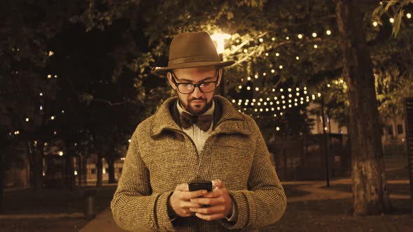 Arab Man Browsing Smartphone on Street