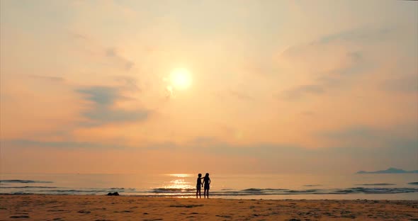 Young Couple Looking Towards the Sun, Against the Sunset, Holding Hands, Go To the Sea