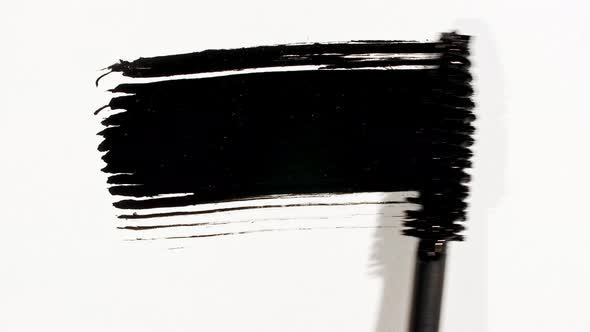 Macro Shot and Slow Motion of a Black Mascara Isolated on White Background