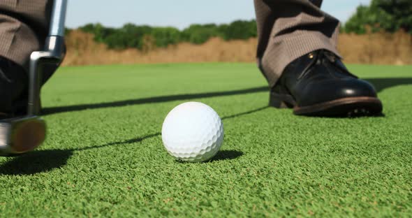 Close Up of Professional Male Player Hitting Ball with Golf Club Practicing Playing Golf Outdoors