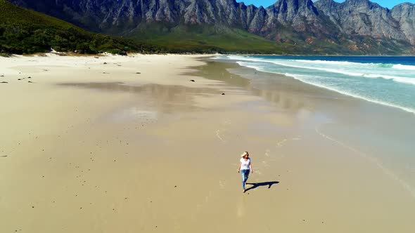 Aerial of woman walking on beautiful beach 4k