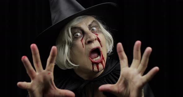 Old Witch Halloween Makeup. Elderly Woman Portrait with Blood on Her Face