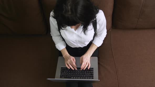 Young Woman Using Laptop at Home Sitting on Sofa