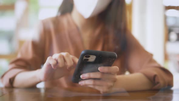 Woman with Mask in Cafe Using Smartphone