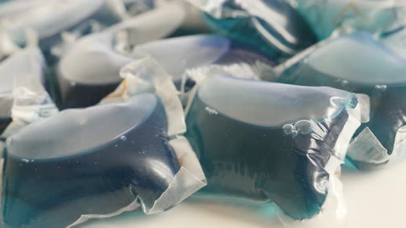 Panning over blue laundry pods on white background 4K 2160p 30fps UltraHD footage - Ultra-concentrat
