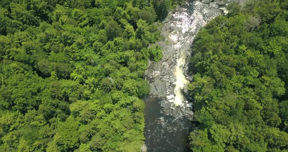 Flying high above a river and the forest at Tobey Falls near Willimantic, Maine.