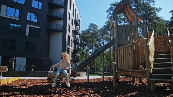 Beautiful Small Girl Play in Playground at Spring