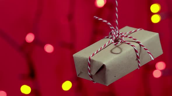 The Decorative Gift Box Tied with a Red Ribbon Rotates on a Rope