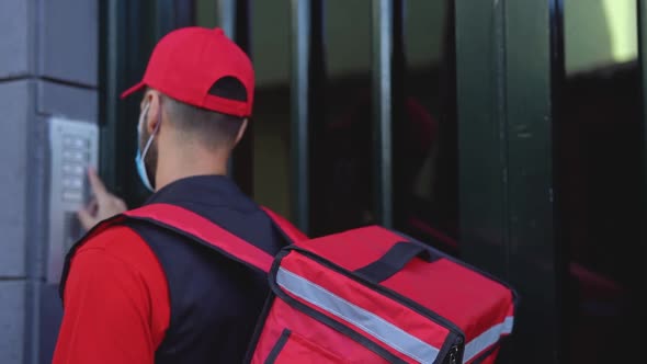 Rider man delivering meal to customers home while wearing face mask