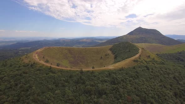 Aerial travel drone view of the Puy de Dome, lava dome volcano in France.