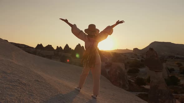 Beautiful Woman Tourist Raises Her Hands Up Rejoicing in the Travel and Sunset