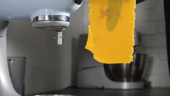 Chef Making Homemade Pasta with Turmeric and Spinage Leaves Inside on Professional Equipment Pasta