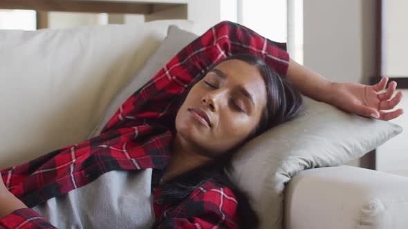 Mixed race woman sleeping on a couch at home