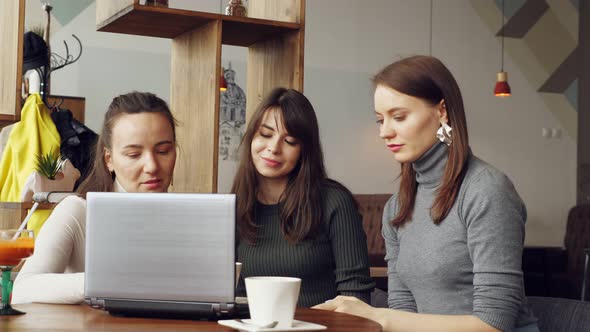 Successful Women Team in Coworking Center Reading a Message with Good News in Laptop an Then Giving