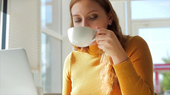 Beautiful Sunny Day Young Woman Drinks Morning Coffee in a Cafe, Making Online a Purchase Easy