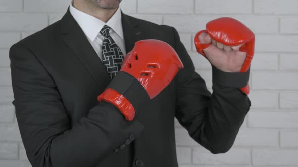 A Man in a Business Suit in Boxing Gloves.