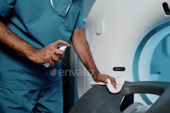 Radiographer Cleaning CT Scanner Bed