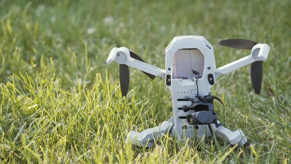 A Sad Damaged Drone on the Green Grass with a Broken Camera and Gimbal