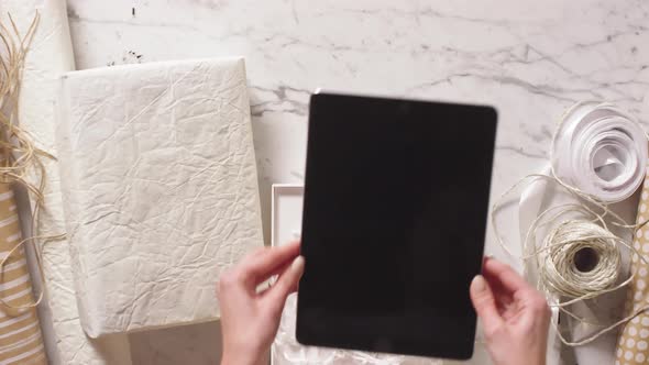 Woman Packing New Digital Tablet into White Gift Box